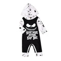 Black or brown cotton Halloween romper with long sleeves and a hood, laid flat.