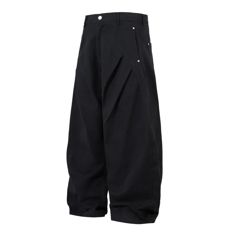 Man wearing black pleated wide-leg casual cotton trousers in a loose fit.