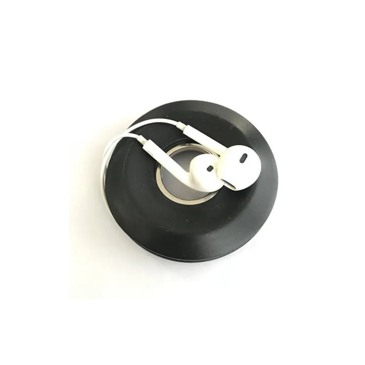 Donut-shaped silicone cord reel in three colours for organising headphones and phone cables