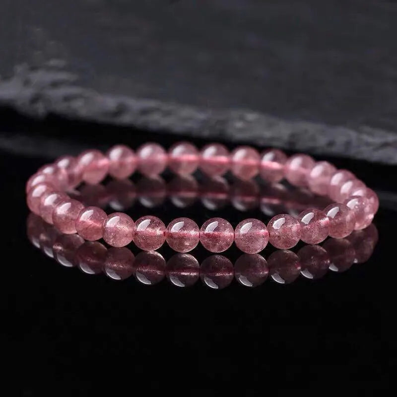 Women's strawberry quartz crystal bracelet with polished beads in three size options on wrist
