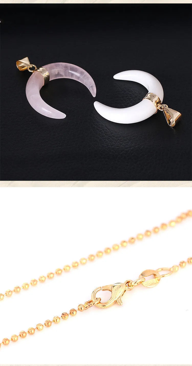Close-up of a moon-shaped pink natural stone pendant on a metallic chain necklace.