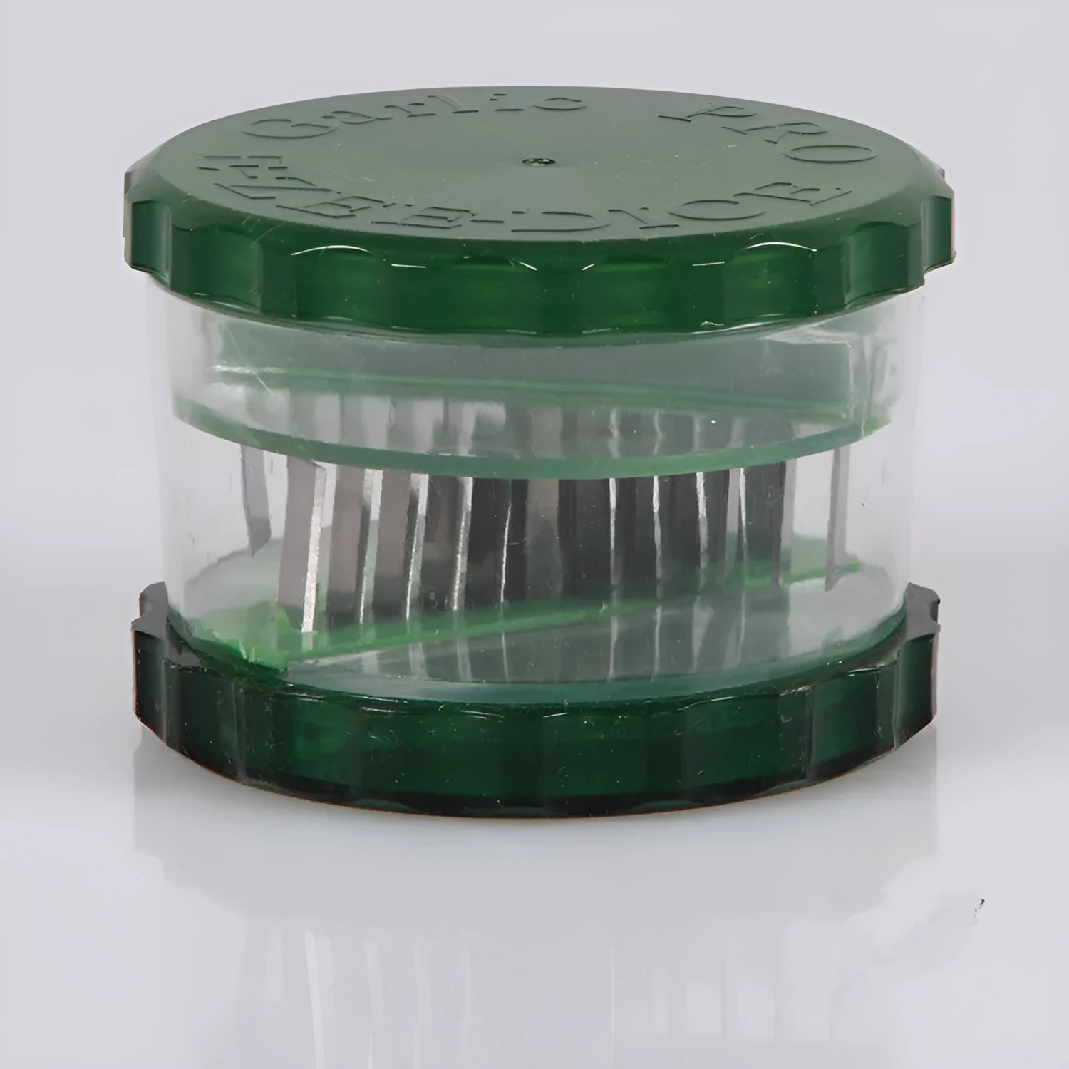 Green transparent plastic garlic peeler kitchen gadget on a countertop.