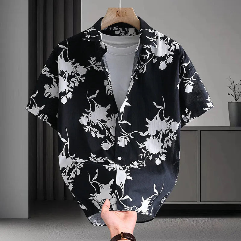 Man wearing a short sleeve cotton Hawaiian shirt with a blue and white floral print.