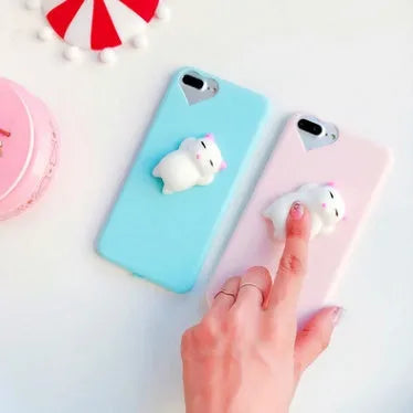 Soft silicone iPhone case with a raised 3D cartoon cat design on the back, shown in pink.