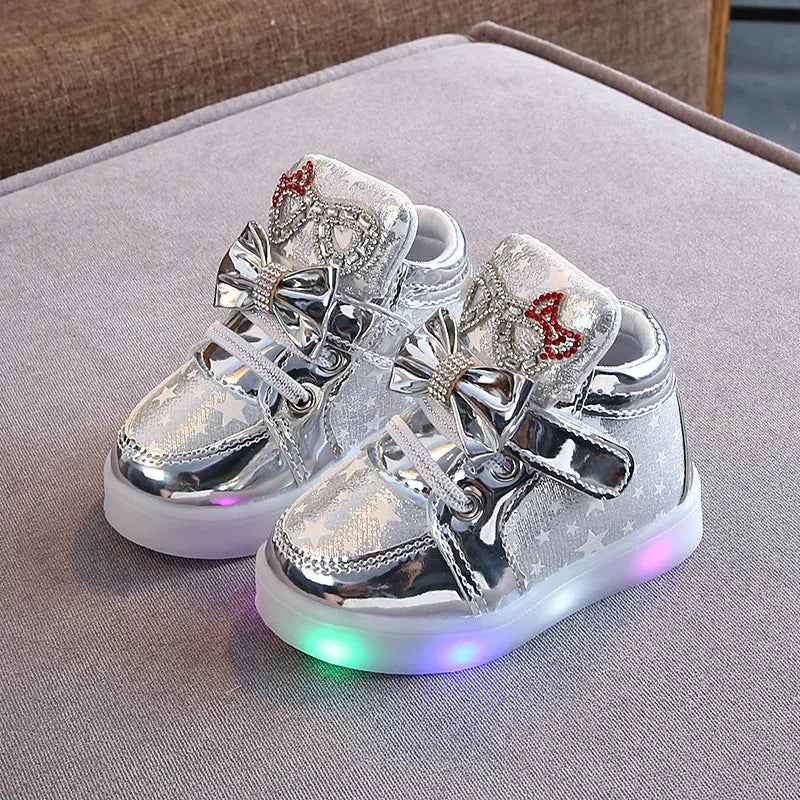 LED magic button sneakers in golden, pink, and silvery metallic finishes with illuminated soles