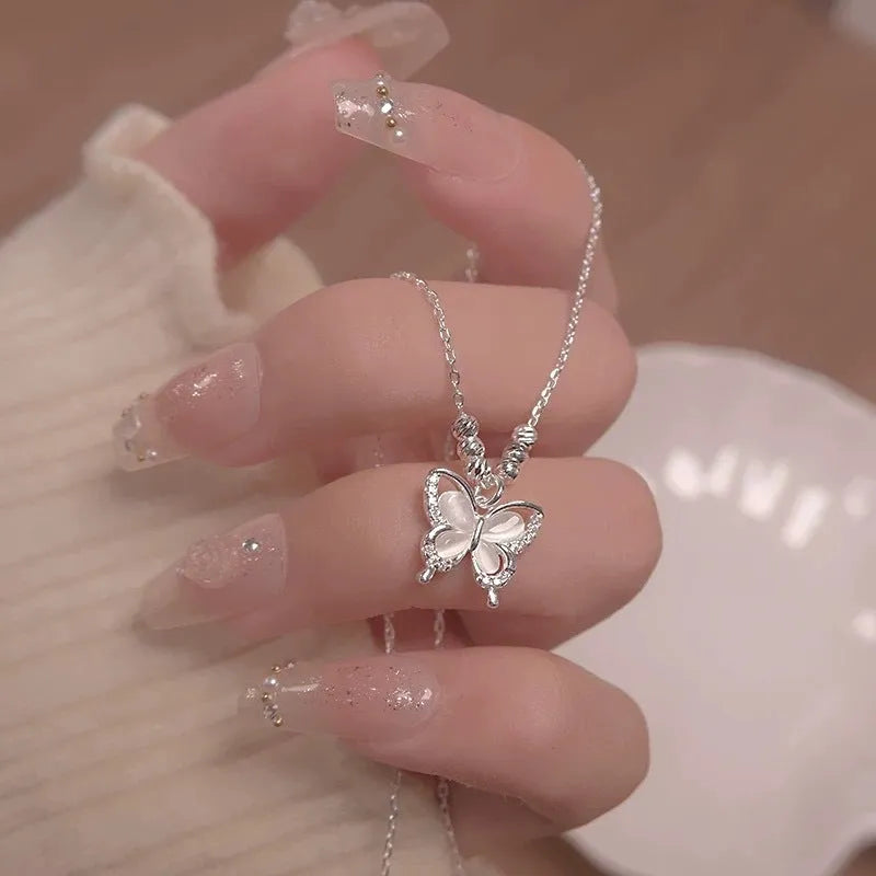 Women's silver butterfly opal pendant necklace on a cross chain, showing adjustable length.