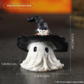 Close-up of a detailed black and a purple resin wizard hat ornament for holiday decoration.