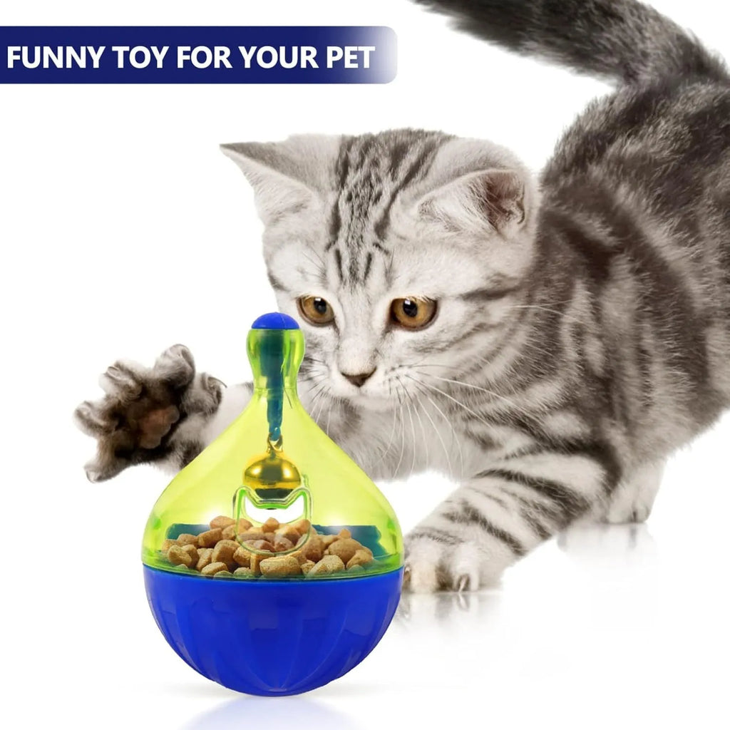 Blue and green tumbler-shaped interactive treat dispenser toy for dogs and cats on a wooden floor.