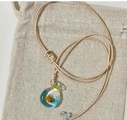 Women's necklace with coloured glaze joker pendant on a beige cotton linen clavicle chain.