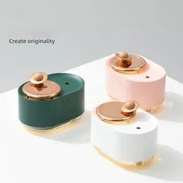 Green rotating planet-shaped USB humidifier with night light on a wooden desk.