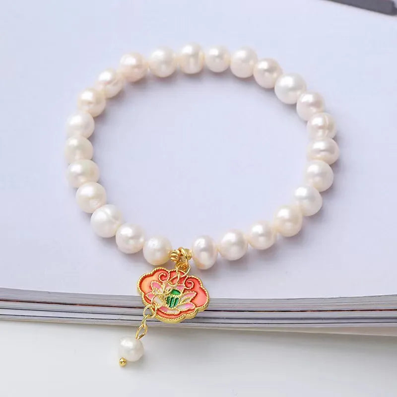 White vintage baroque bracelet with a freshwater pearl and goldfish lotus pendant.