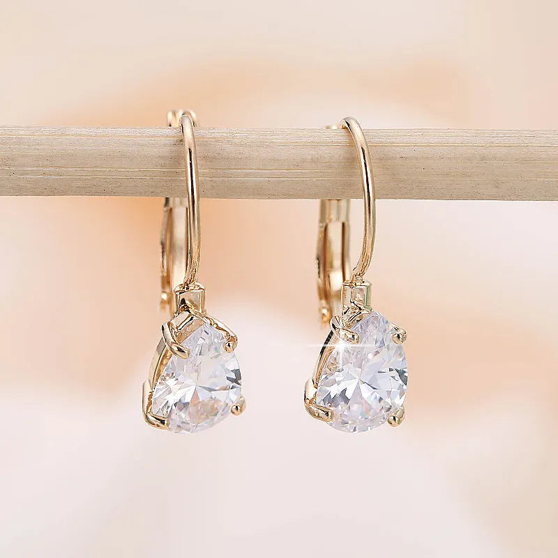 Women's drop-shaped metal earrings in gold or platinum colour with inlaid gem details