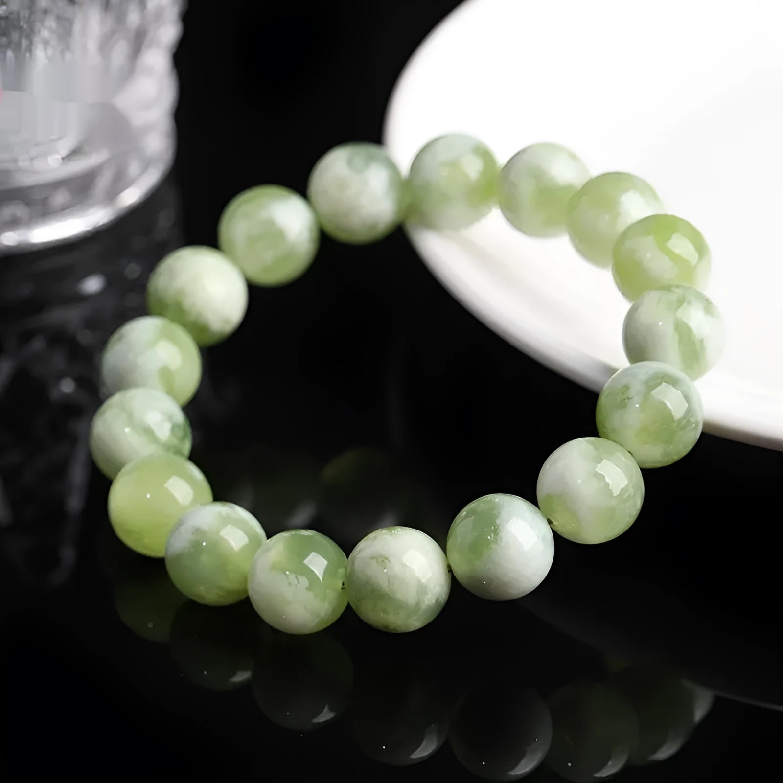Polished green milk-in-water Xiuyan jade bracelet showing single circle of beads on a wrist.