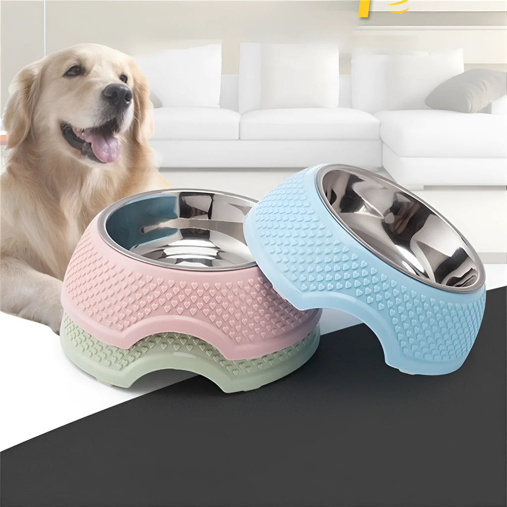 Set of four coloured stainless steel pet bowls with non-slip bases on a table.
