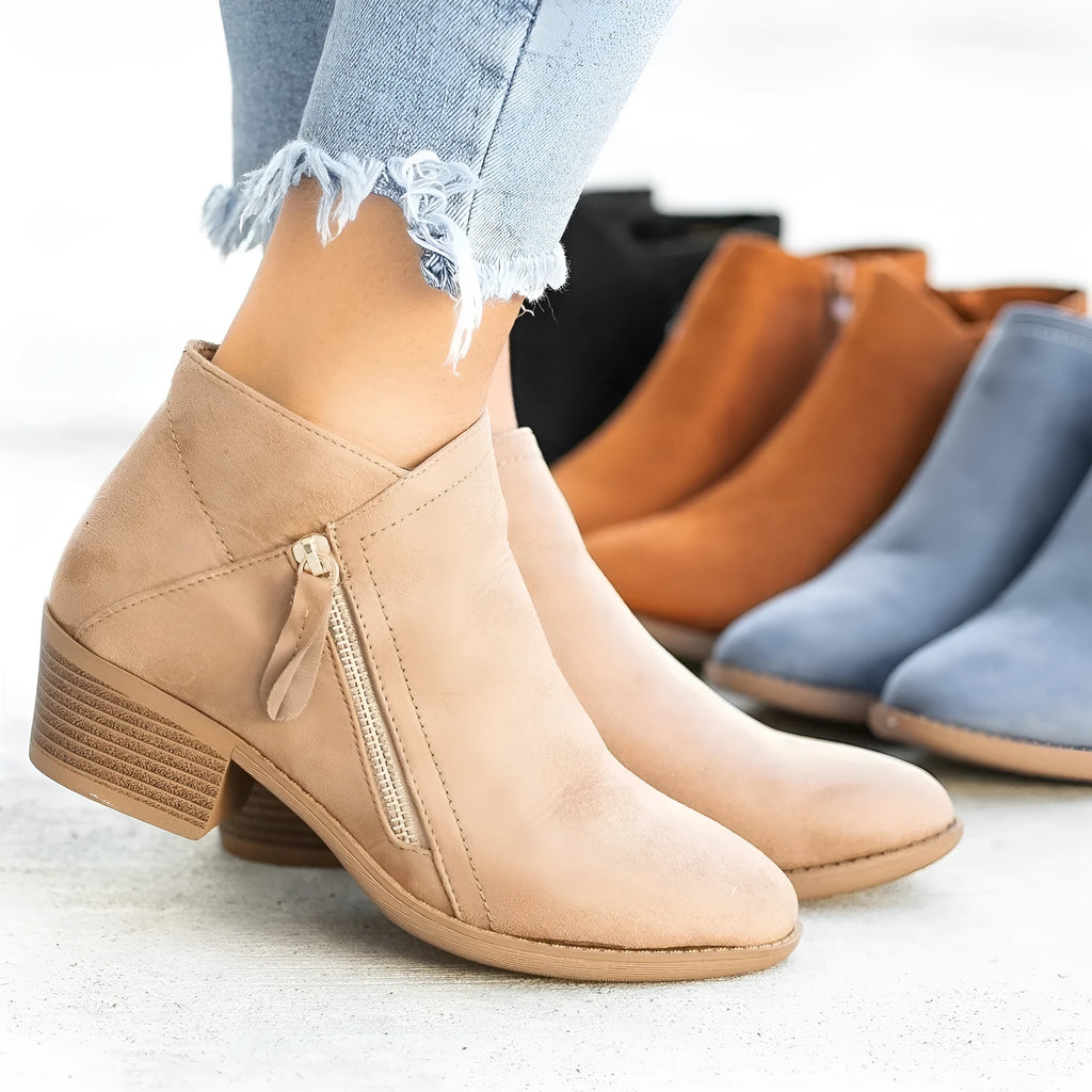 Women's beige suede ankle boot with side zip, lace-up front, and chunky composite sole.
