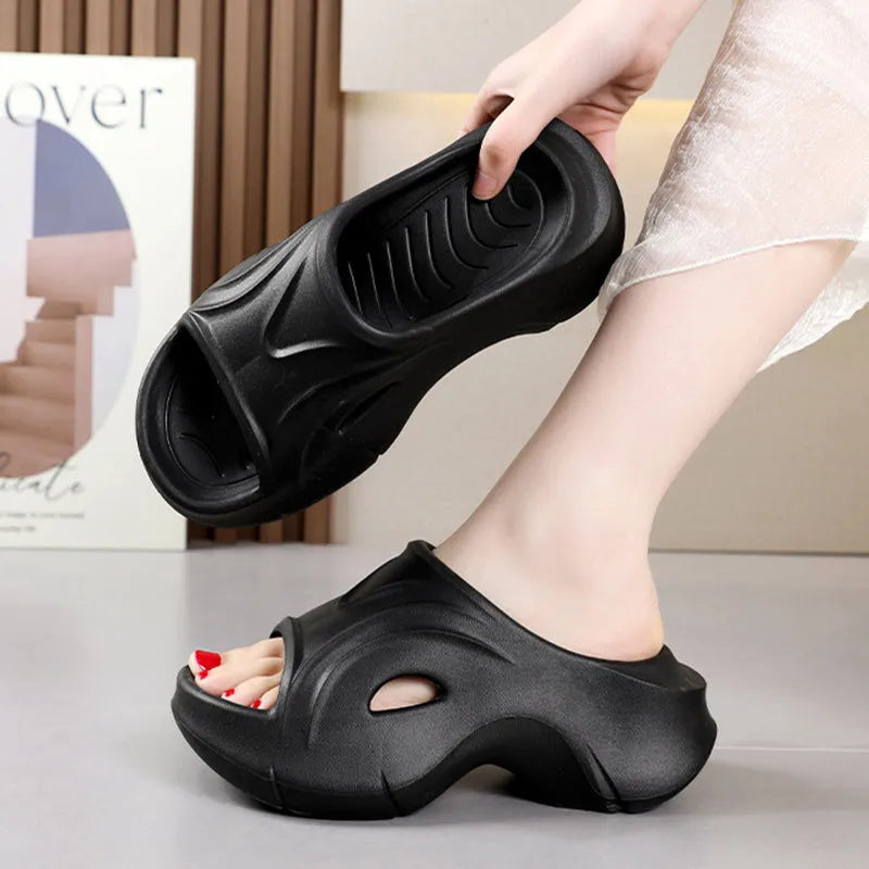 Women's white thick-soled EVA slippers on a sandy beach background.
