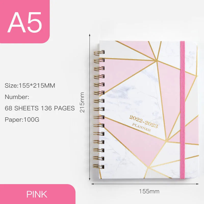 A5 spiral notebook with colourful floral cover, open to show lined pages and metal coil binding