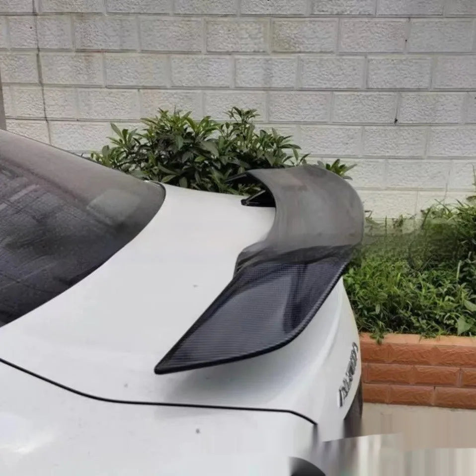 Universal punch-free car tail wing spoiler in ABS plastic shown in bright black and carbon pattern finishes.
