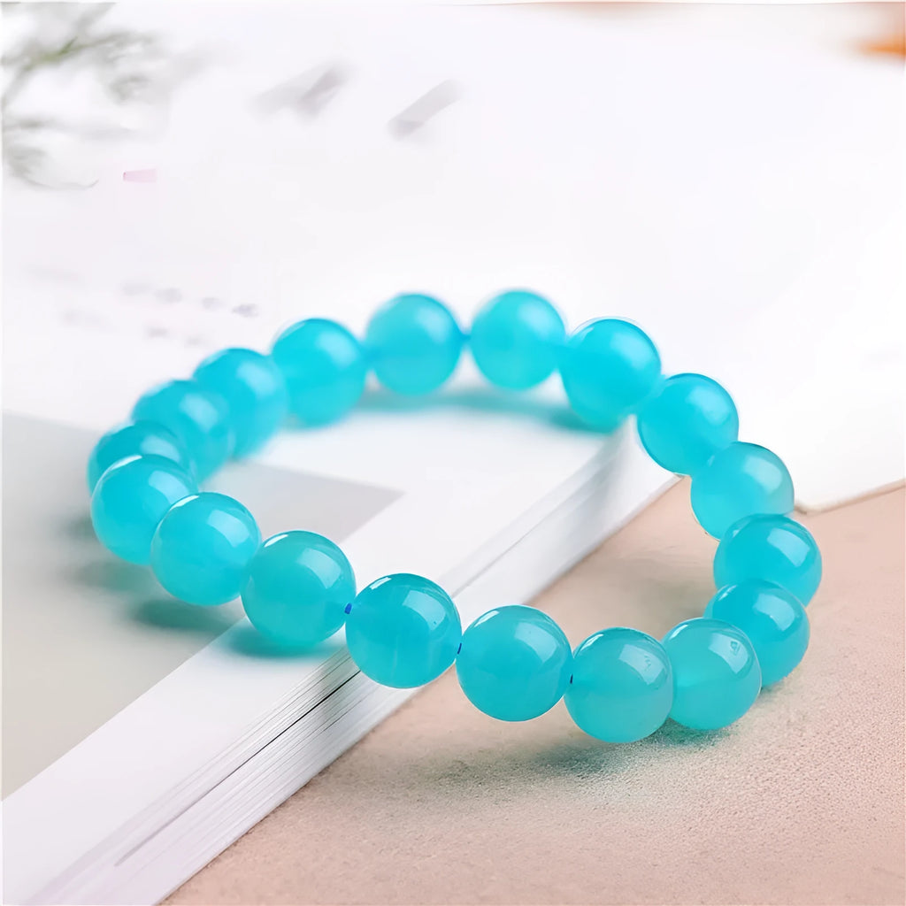 Selection of polished blue-green Amazonite scattered beads in different sizes for making a crystal bracelet.