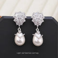 Women's drop-shaped pearl earrings with zircon stone accents and 18K gold plating.