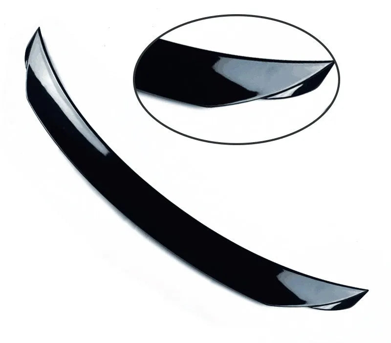 Bright black aftermarket tail trim spoiler for a Mazda 3 car rear bumper.