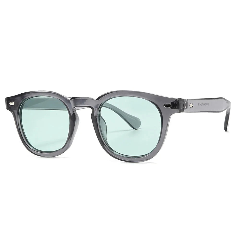 Round retro plastic sunglasses on a table, showing bright black frame with grey lens.