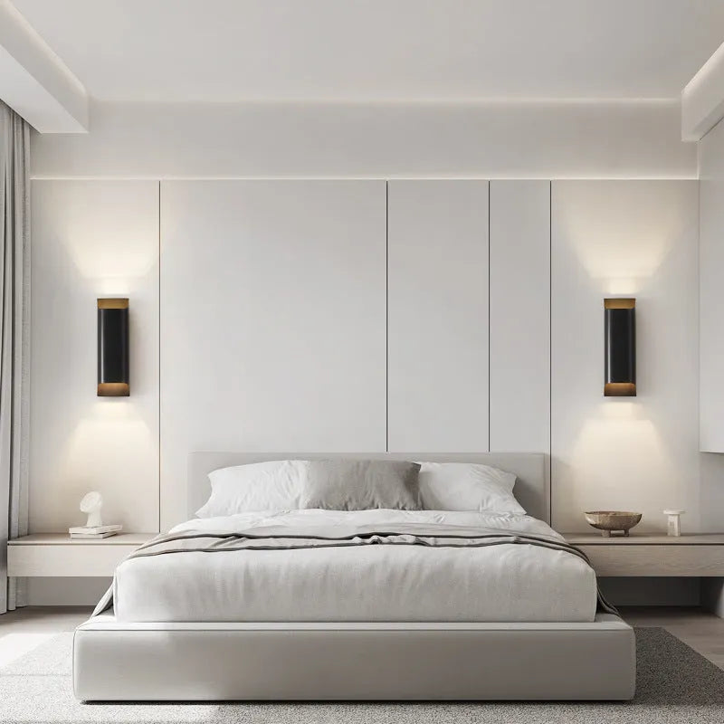 Minimalist copper wall lamp in black gold finish mounted beside a bed