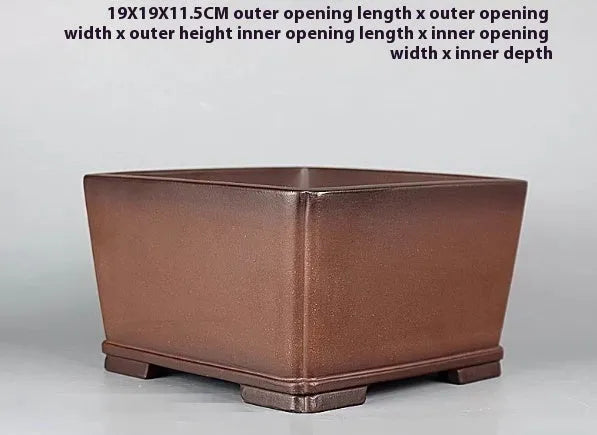 Brown handmade antique purple clay flower pot for plants on a windowsill.