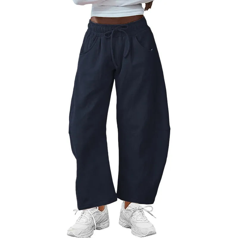 Women's loose cropped sweatpants with elastic drawstring waist in apricot colour showing side pockets and street fashion styling
