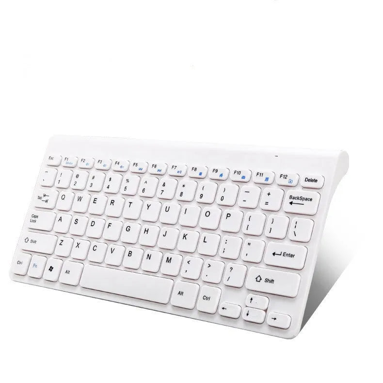 Black and white wireless keyboard and mouse set with USB receiver on a wooden desk.