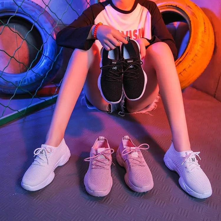 Women's white thick-soled flying woven trainers with pink perforations and a front strap on a rubber sole.
