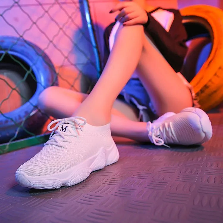 Women's white thick-soled flying woven trainers with pink perforations and a front strap on a rubber sole.
