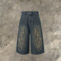 Men's black denim shorts with cropped length and flame embroidery patch design on leg