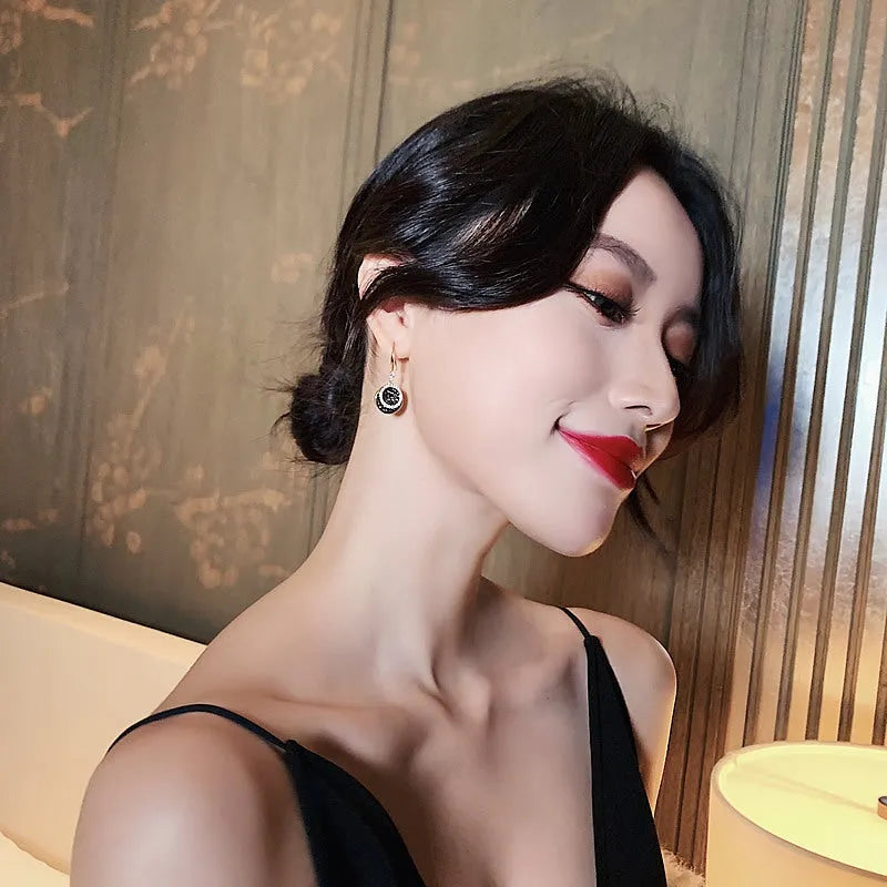 Black geometric alloy drop earrings with round pieces measuring 3.6cm length