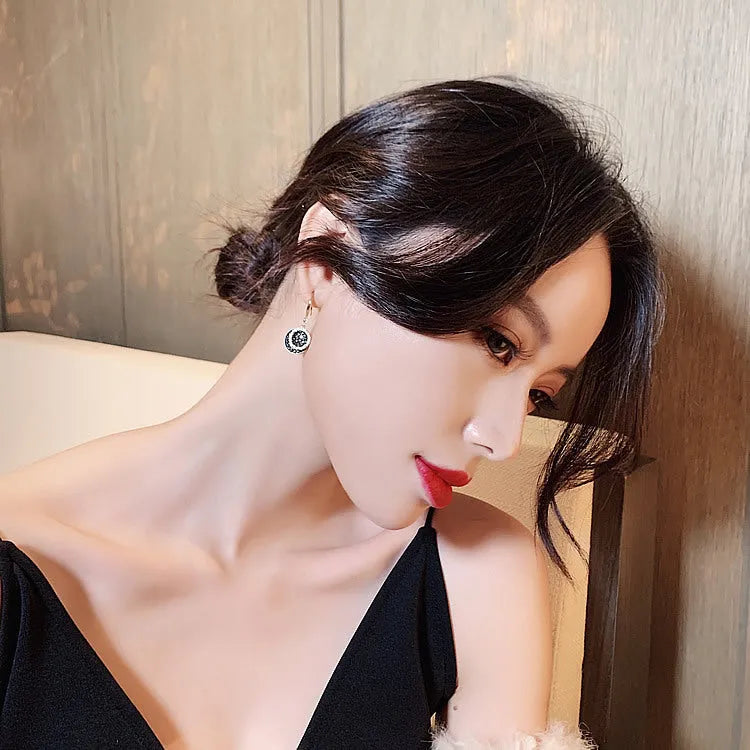Black geometric alloy drop earrings with round pieces measuring 3.6cm length
