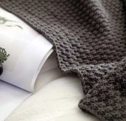 Nordic fringed knit ball acrylic blanket in beige colour, measuring 130 by 170 centimetres.