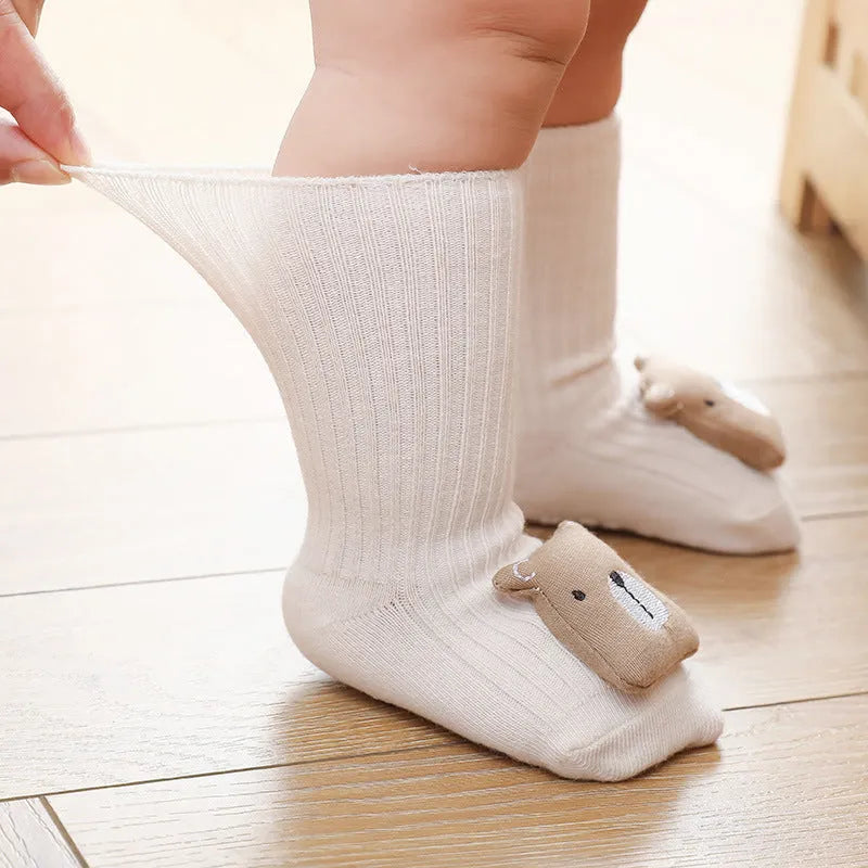 Baby socks with anti-slip glue dots on soles in combed cotton, showing mid-tube height and various colour options