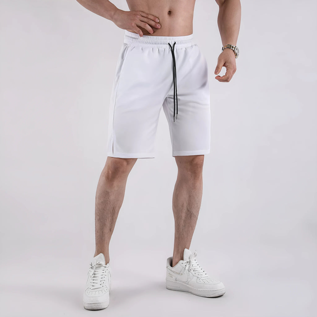 Man wearing black quick-drying mesh fitness shorts with an elastic mid-waist and loose fit.