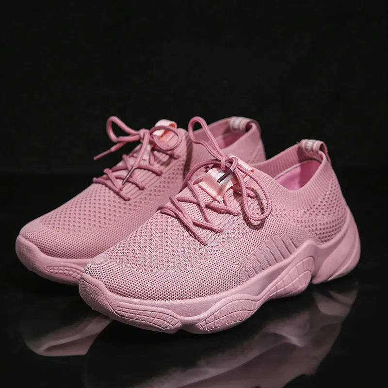 Women's white thick-soled flying woven trainers with pink perforations and a front strap on a rubber sole.