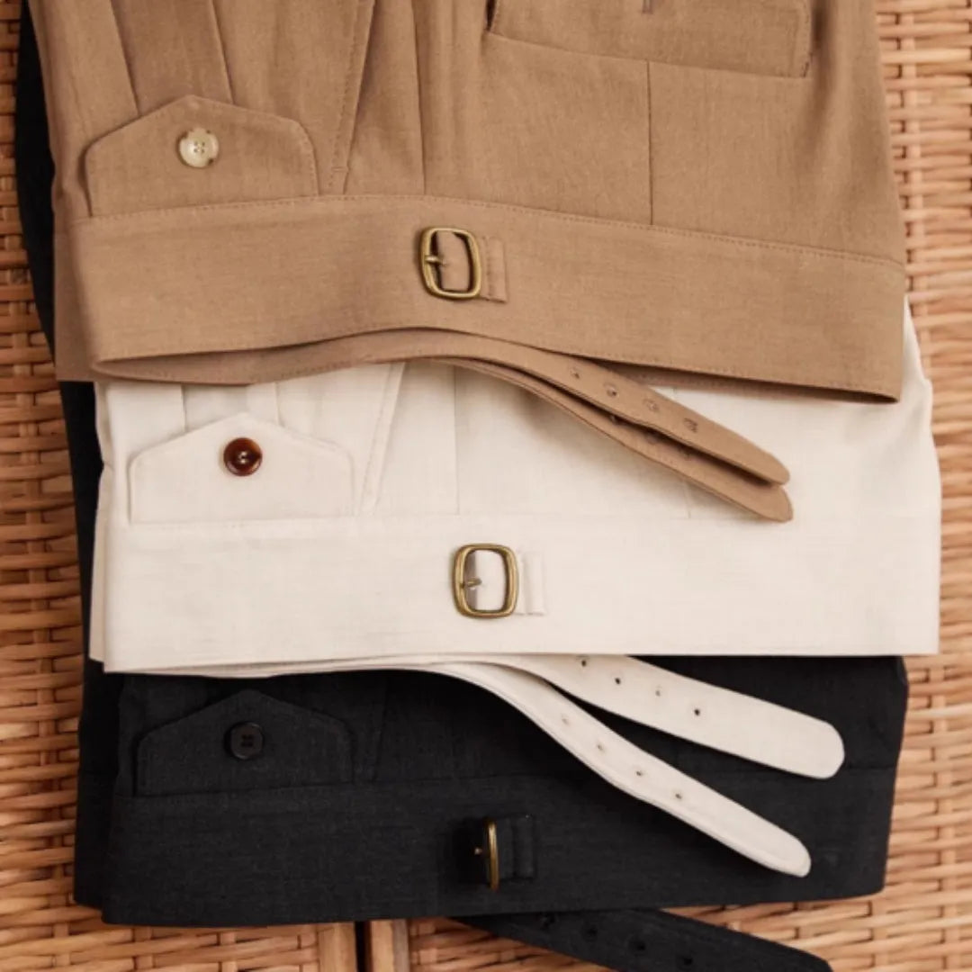 Men's slim fit straight leg trousers in dark grey, light brown, and light apricot colours on a hanger.