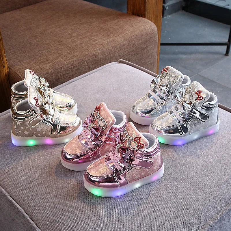 LED magic button sneakers in golden, pink, and silvery metallic finishes with illuminated soles