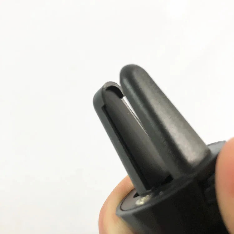 Black car phone holder mounted on vehicle air vent showing smartphone placement