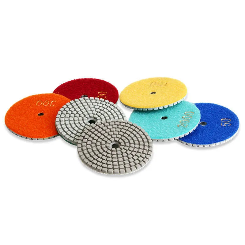 Set of 10 emery stone polishing discs with grits from 50 to 3000 mesh on a grey background.