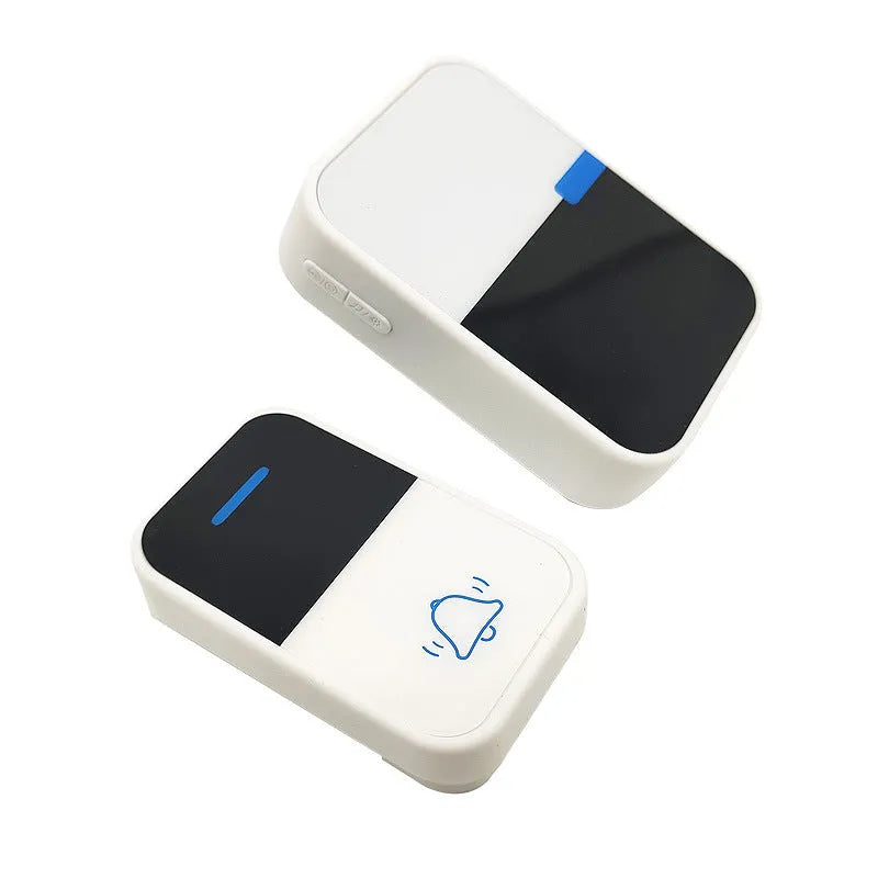 Modern white plastic wireless doorbell receiver and self-generating push-button transmitter on a table.