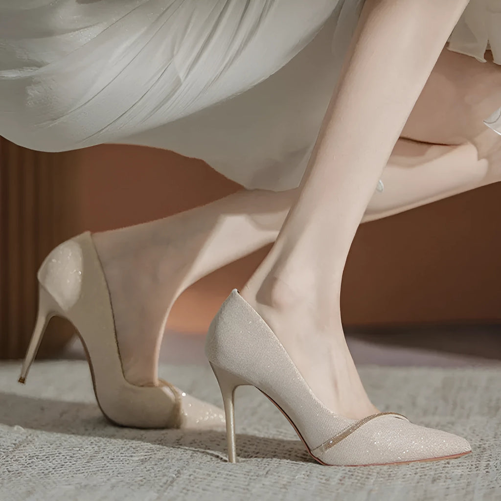 Women's black stiletto high heels with pointed toe and oversleeve design on a white background.