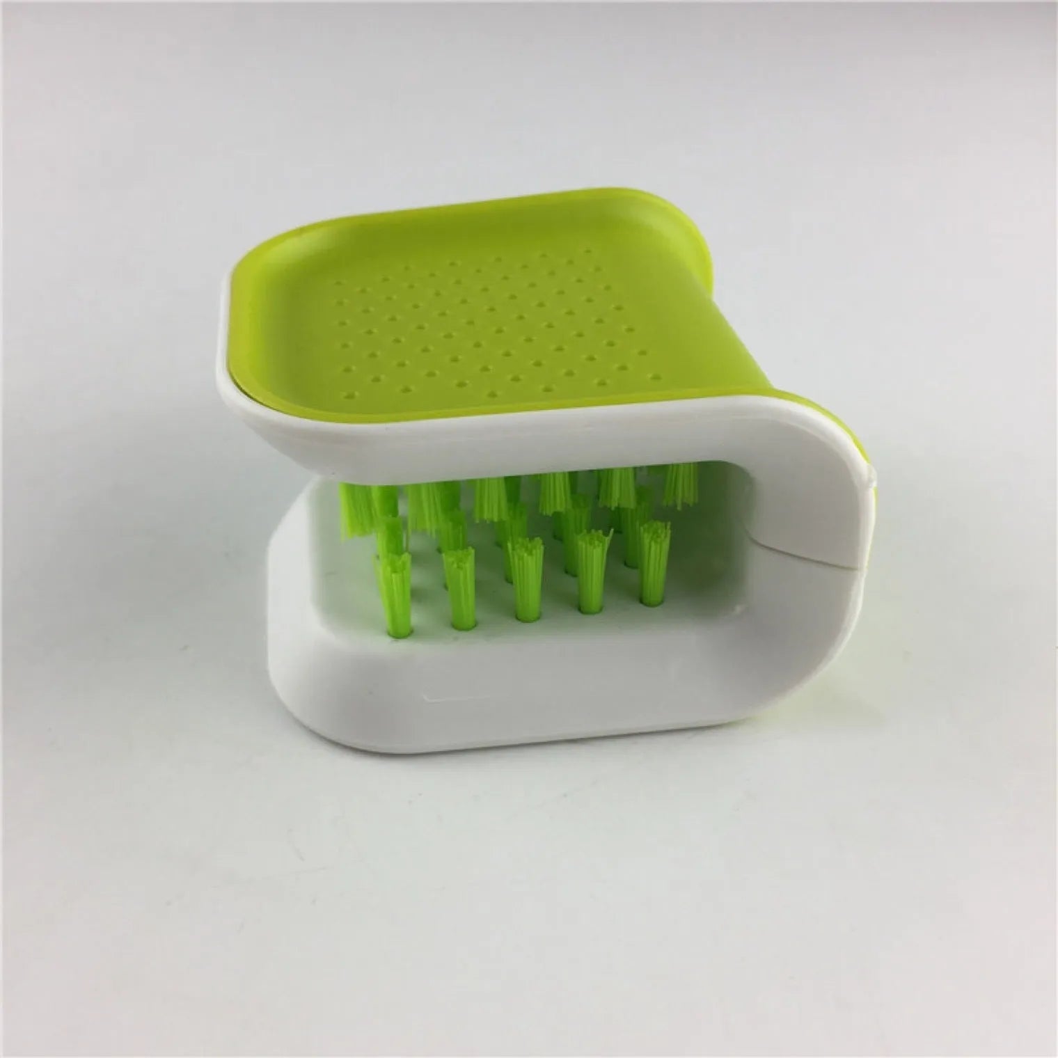 Blue U-shaped plastic brush with bristles for cleaning knives and cutlery in a kitchen.