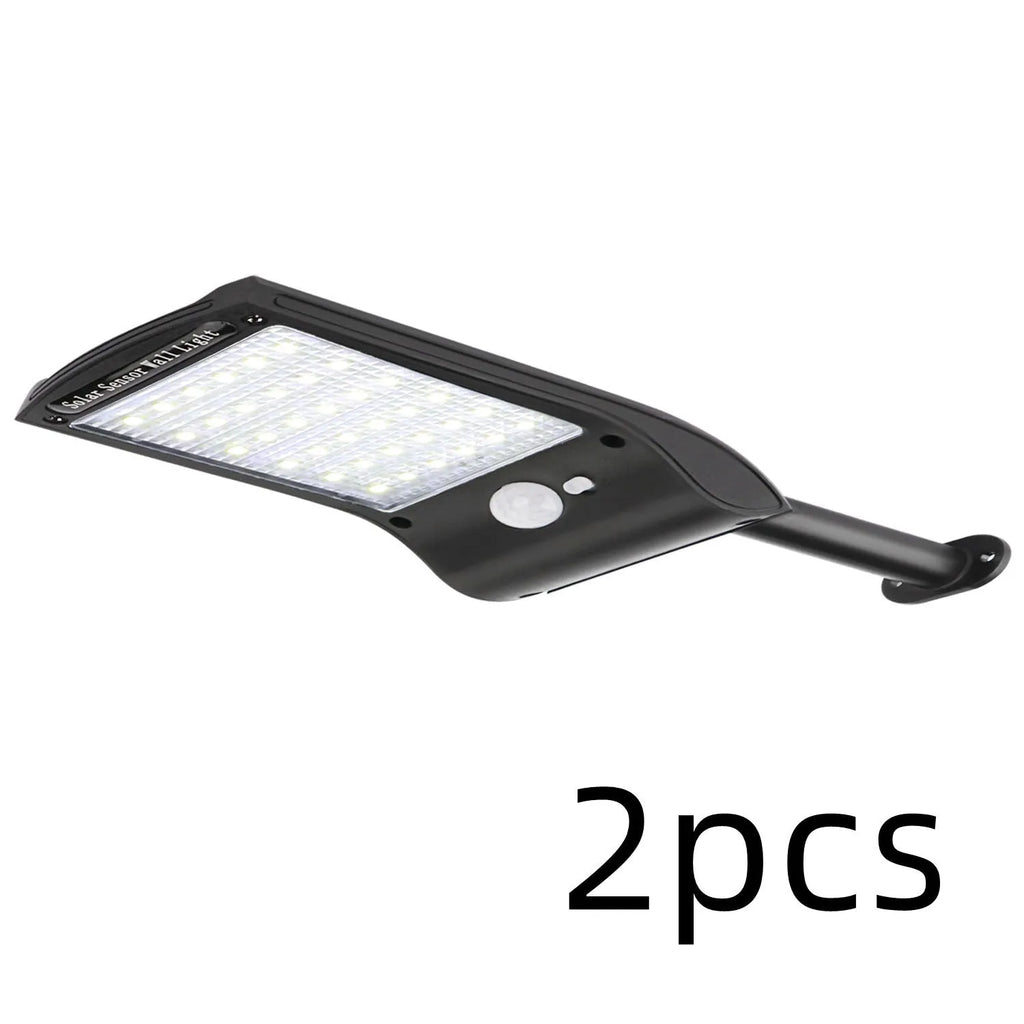 Black L808B solar wall light with diamond-pattern casing and adjustable pole mounted on an exterior wall.