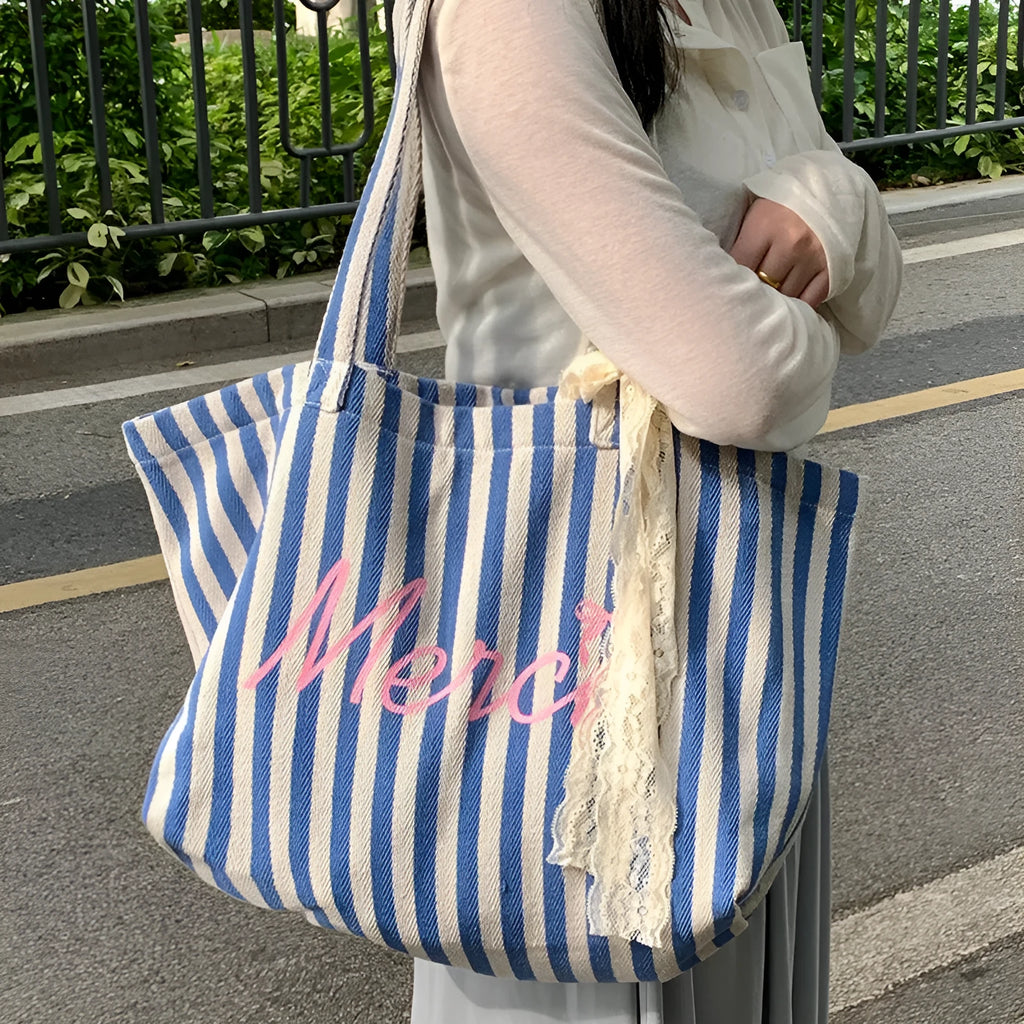 Pink cotton canvas bag with a printed design of blue and white striped letters.