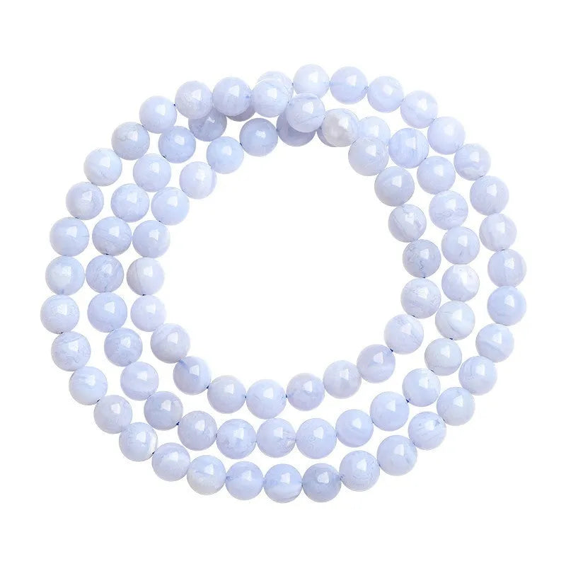 Blue agate bracelet with multi-circle pattern and scattered striped beads on a wrist.