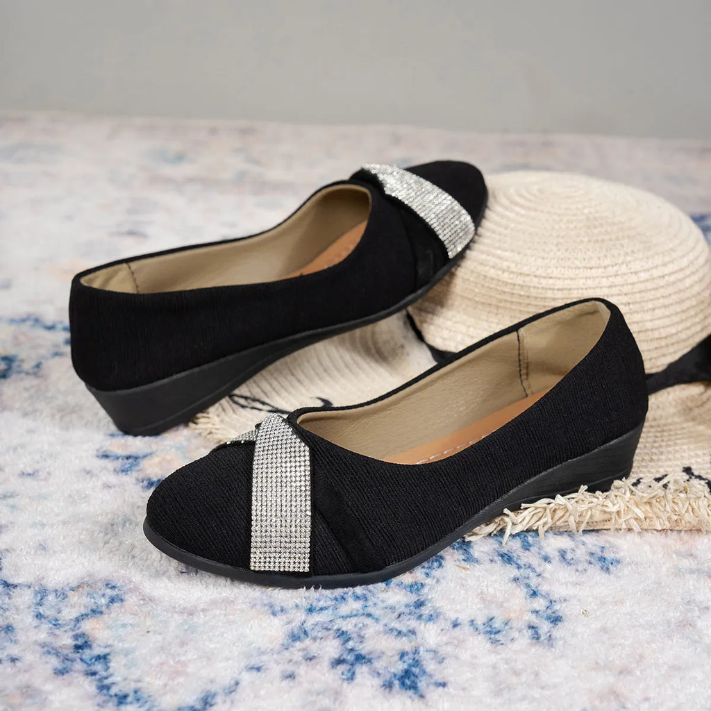 Women's black low-cut slip-on casual shoes with rhinestone detail and a short chunky heel.